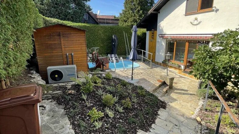 Gepflegter Gartenbereich mit kleinem Pool, Gartenhaus und Steinweg zum Haus.