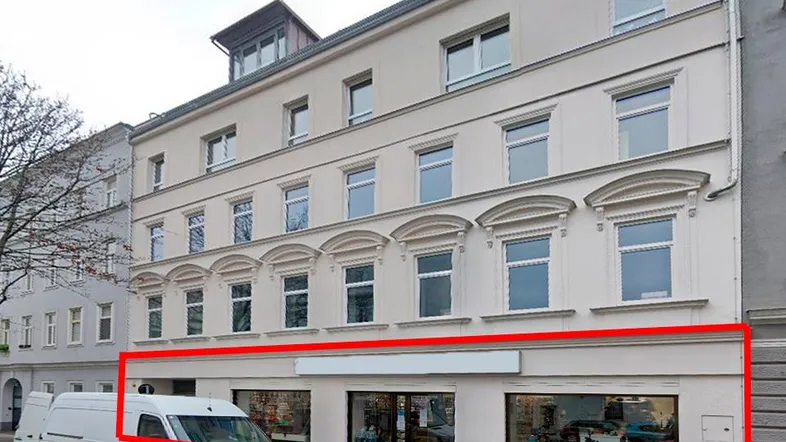 Gebäudeansicht mit Ladenlokal im Erdgeschoss und darüberliegenden Wohnungen, umrandet in Rot.