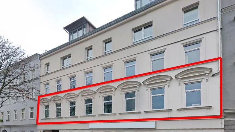 Historisches Gebäude mit renovierter Fassade, großen Fenstern und einem Geschäft im Erdgeschoss.