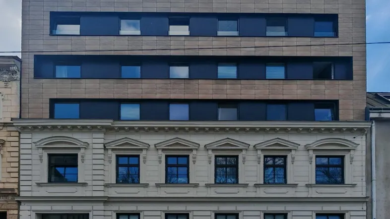 Fassade eines Gebäudes, das moderne und klassische Architekturelemente vereint.