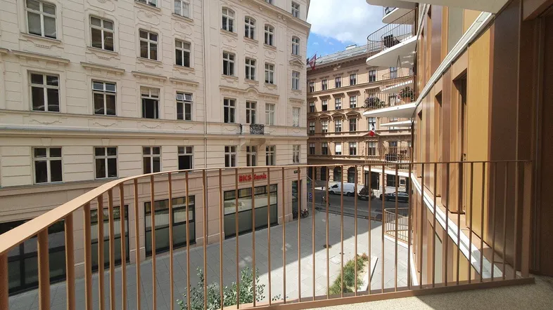 Balkon mit Blick auf die umliegenden Gebäude und die belebte Straße der Stadt.