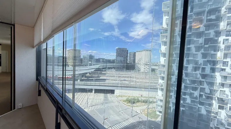 Verglaste Loggia mit weitem Blick über die Stadt und Bahnanlagen.