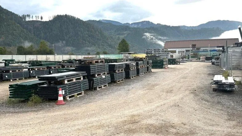 Weitläufiges Außengelände mit gelagerten Materialien und Blick auf die umliegenden Berge.