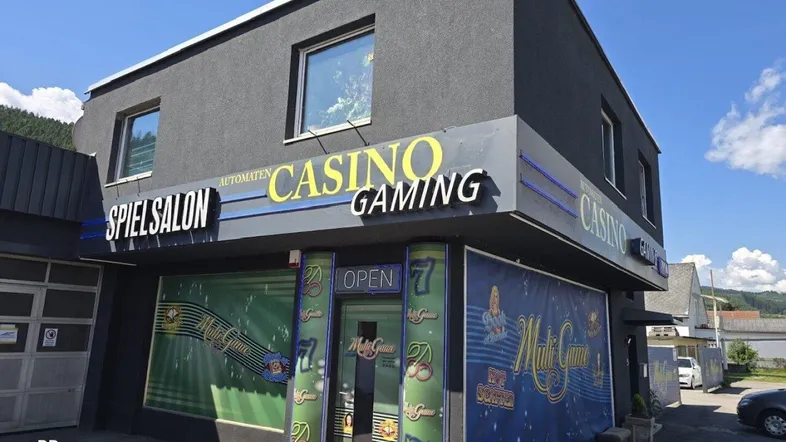 Modernes Geschäftsgebäude mit auffälliger Casino-Beschilderung und Eingangsbereich unter blauem Himmel.