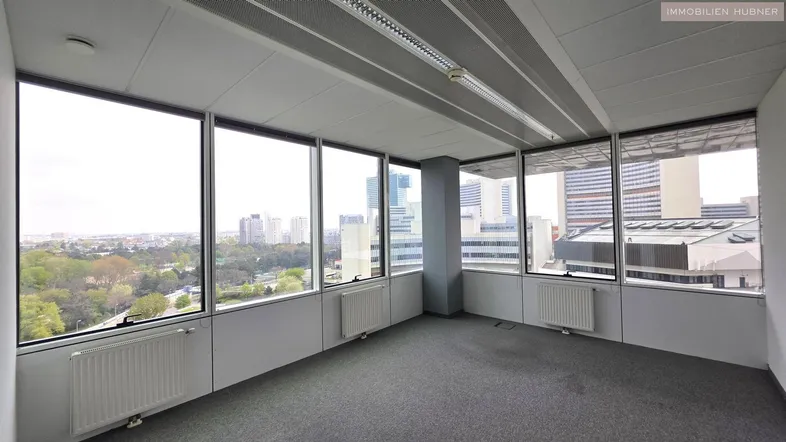 Geräumiges Büro mit großen Fenstern, die einen weiten Blick auf die Stadt und viel natürliches Licht bieten.