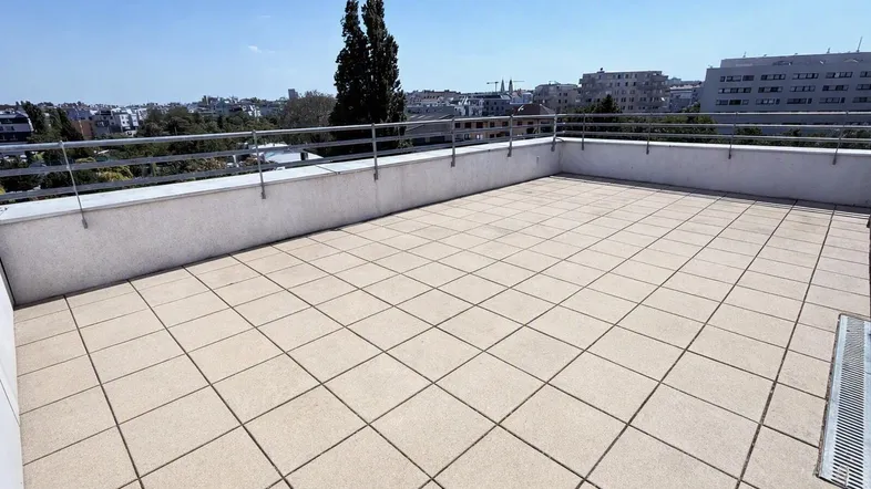 Große, sonnige Dachterrasse mit Fliesenboden und weitem Blick über die Stadt.