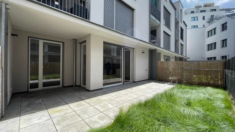 Geräumige Terrasse mit angrenzender Rasenfläche und Zugang zu den Wohnräumen im Erdgeschoss.
