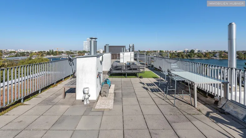 Große Dachterrasse mit Sitzgelegenheiten und weitem Blick über die Stadt und den See.
