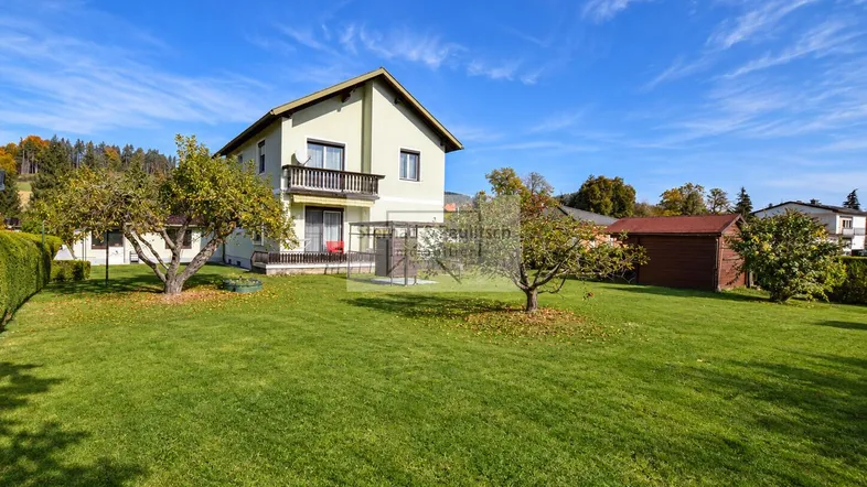 Großzügiger Gartenbereich mit gepflegtem Rasen und Obstbäumen vor dem Einfamilienhaus.