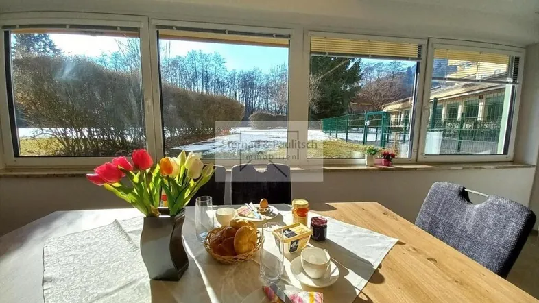 Helles Esszimmer mit Holztisch und Blick ins Grüne, ideal für gemütliche Mahlzeiten.