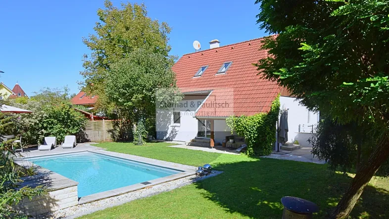 Großzügiger Gartenbereich mit privatem Pool, Liegewiese und Blick auf das charmante Wohnhaus.