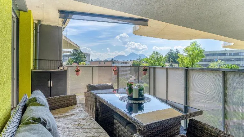 Möblierter Balkon mit Bergblick und gemütlicher Sitzgelegenheit im Freien, ideal zum Entspannen.