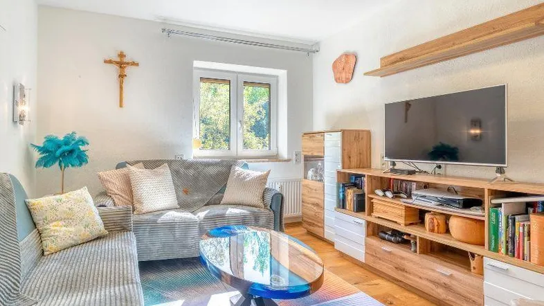 Gemütliches Wohnzimmer mit Holzboden, bequemen Sofas und einem modernen Couchtisch.