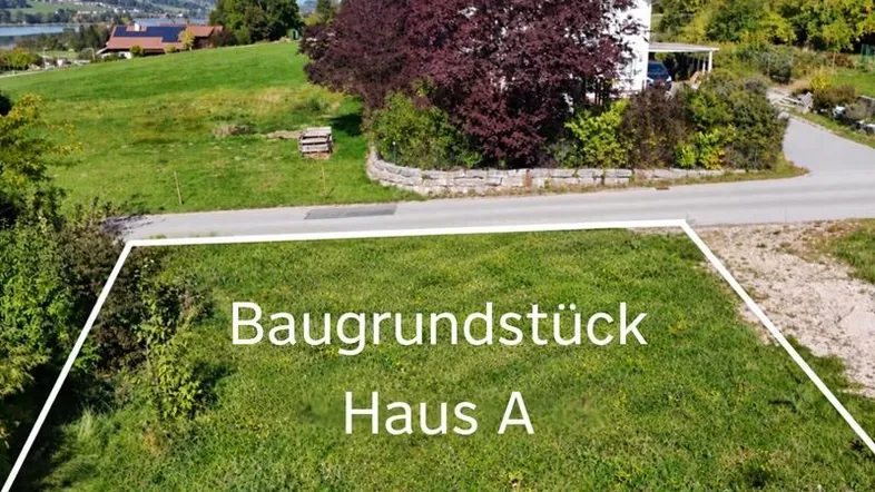Luftaufnahme eines Baugrundstücks für Haus A mit Blick auf die umliegende Landschaft und einen See.