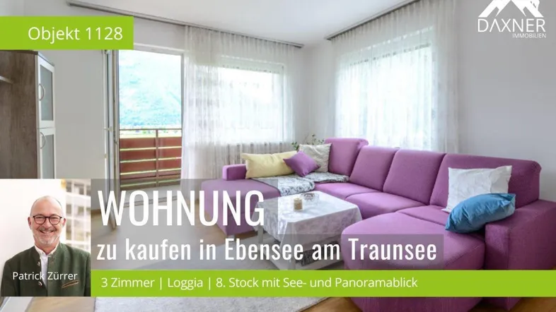 Helles Wohnzimmer mit lila Ecksofa, Holzboden und Zugang zum Balkon mit Panoramablick.
