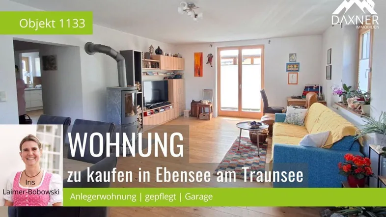 Helles Wohnzimmer mit Kaminofen, Holzboden und Zugang zu einem Balkon.