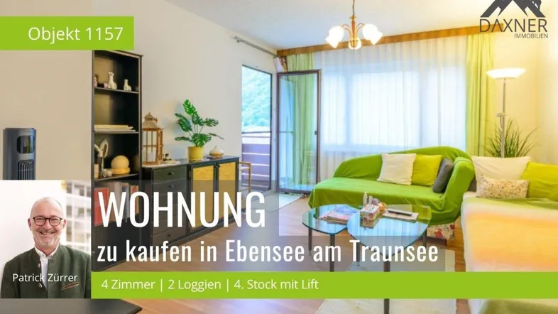 Helles Wohnzimmer mit grünem Sofa, Parkettboden und Zugang zu einem Balkon mit Bergblick.