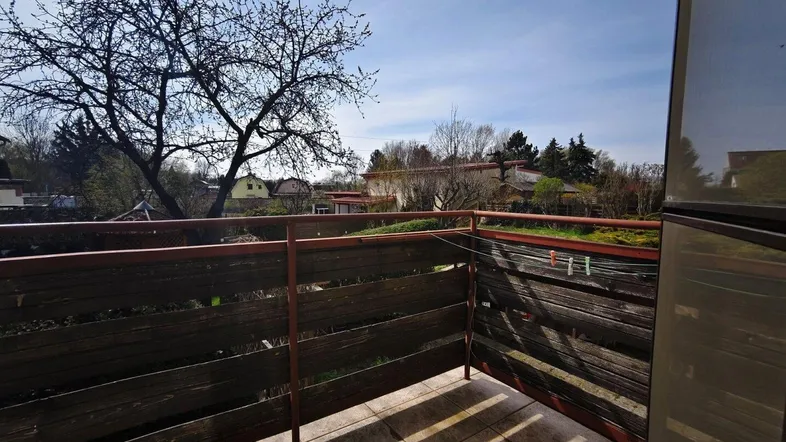 Kleiner Balkon mit Holzgeländer und Blick ins Grüne, ideal für entspannte Stunden im Freien.