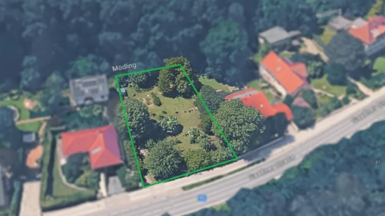 Luftaufnahme des Grundstücks mit grüner Umrandung und umliegender Bebauung in Mödling.