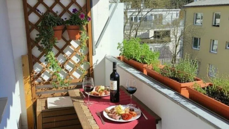 Gemütlicher Balkon mit Esstisch, Pflanzen und Markise, ideal für Mahlzeiten im Freien mit Bergblick.
