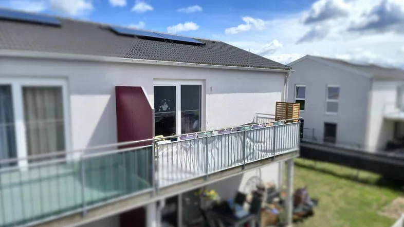 Balkon mit Glasgeländer und Sichtschutz, bietet Platz für Entspannung im Freien.