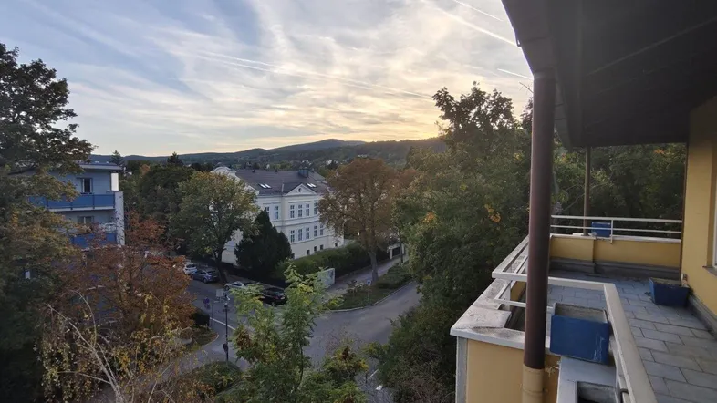 Geräumiger Balkon mit Blick auf die umliegende Landschaft und den Sonnenuntergang.