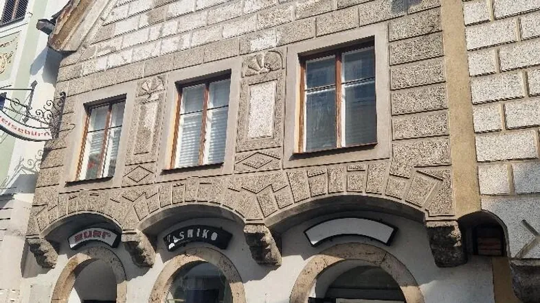 Historisches Gebäude mit markanter Steinfassade und gewölbten Eingängen in der Altstadt.