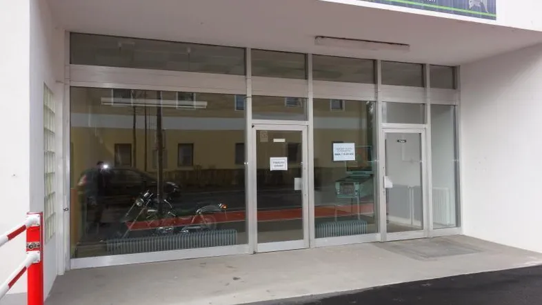 Die moderne Ladenfront des Geschäftsgebäudes mit großen Glasfenstern und Eingangstüren.