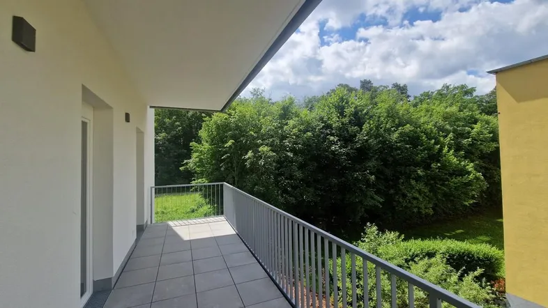 Geräumiger Balkon mit Fliesenboden und Blick ins Grüne, ideal zum Entspannen im Freien.
