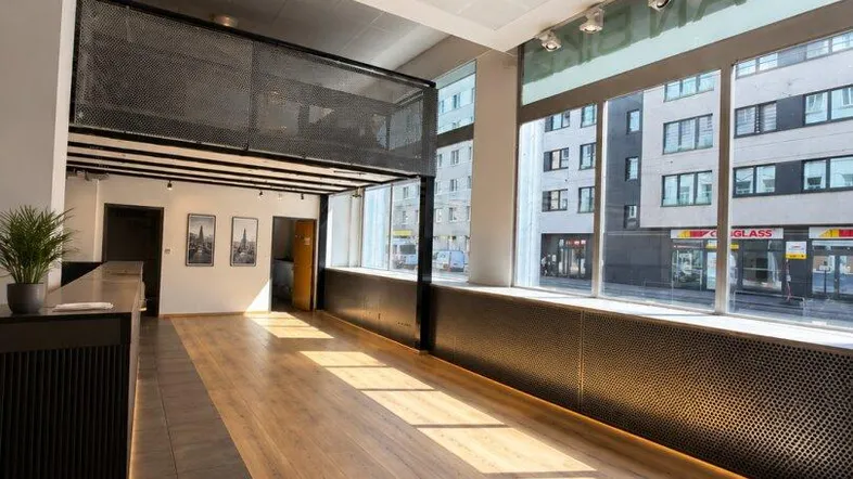 Heller Empfangsbereich mit hohen Decken, großen Fenstern und einer Galerie im Obergeschoss.