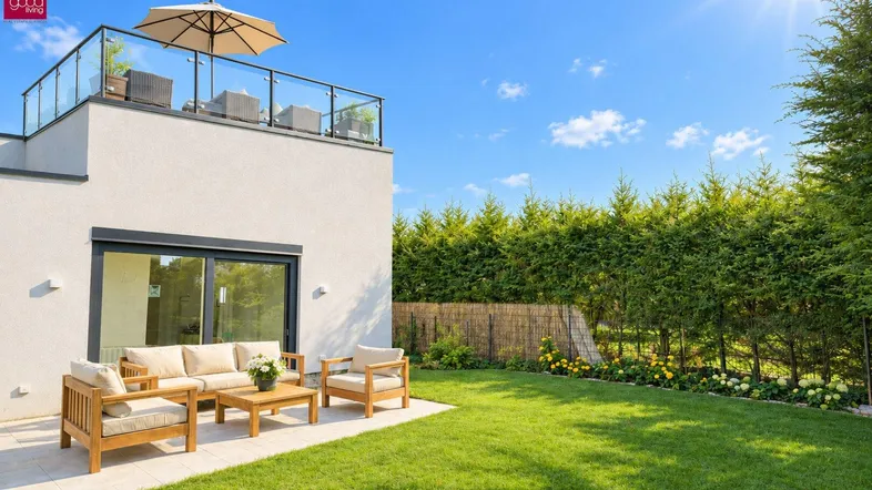 Sonniger Außenbereich mit möblierter Terrasse, grünem Rasen und einer Dachterrasse darüber.