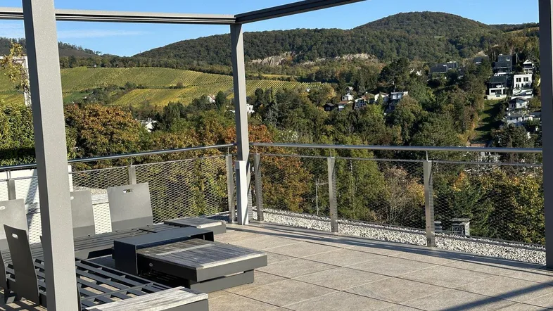 Große Dachterrasse mit moderner Pergola, bequemen Loungemöbeln und weitem Blick ins Grüne.