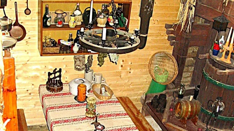 Rustikaler Innenraum mit Holzwänden, einem gedeckten Tisch und traditionellen Dekorationen, die eine gemütliche Atmosphäre schaffen.