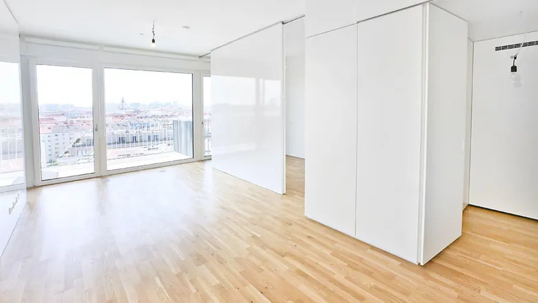 Helles Wohnzimmer mit Holzboden, großen Fenstern und weitem Stadtblick.
