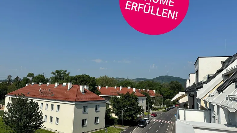 Panoramablick auf eine Wohngegend mit modernen und traditionellen Gebäuden unter blauem Himmel.