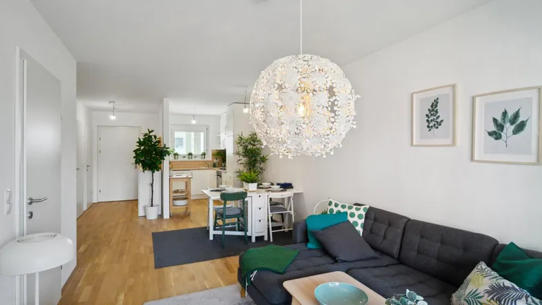 Helles, offenes Wohn- und Esszimmer mit Holzboden und moderner Einrichtung.