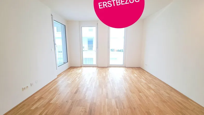 Lichtdurchfluteter Wohnraum mit hochwertigem Parkettboden und großen Fenstern zum Außenbereich.