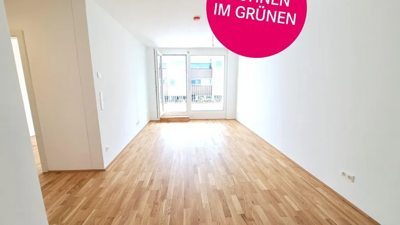 Helles Wohnzimmer mit Eichenparkett und Zugang zu einem Balkon, ideal für modernes Wohnen.