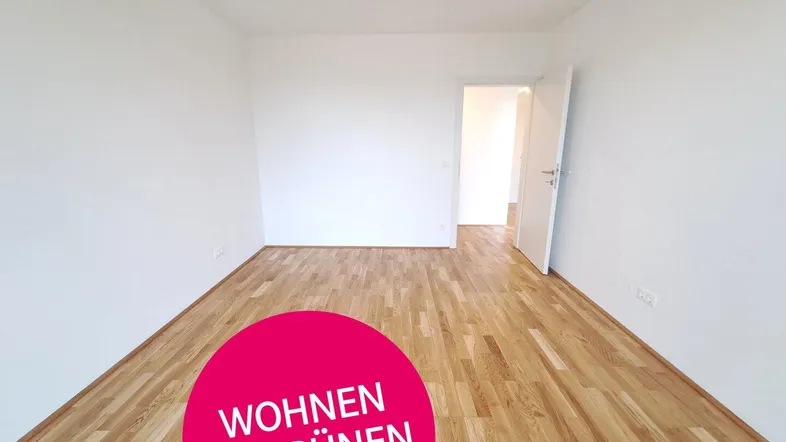 Heller, leerer Raum mit neuem Holzparkettboden und weißen Wänden, bereit zum Einzug.
