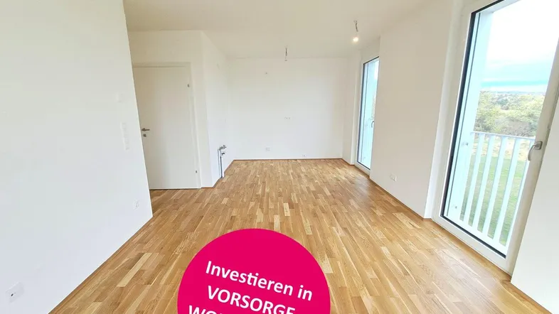 Heller, leerer Raum mit Parkettboden und großen Fenstern, ideal für Wohnzwecke.