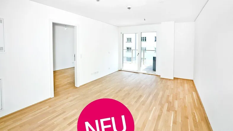 Helles, leeres Zimmer mit Parkettboden und Zugang zu einem Balkon, ideal für Wohn- oder Schlafbereich.
