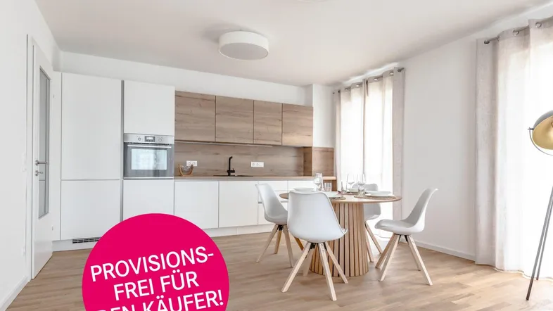 Moderne, offene Küche mit Essbereich, hellen Holzfronten und integrierten Geräten in einem lichtdurchfluteten Raum.