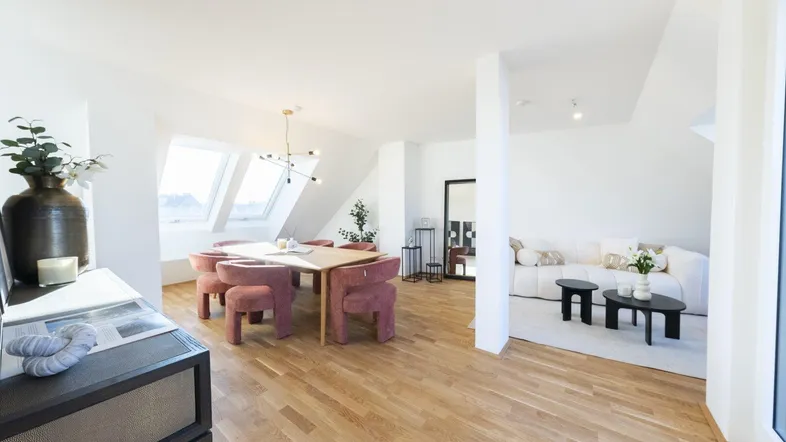 Heller, offener Wohn- und Essbereich mit Holzboden und großen Dachfenstern, modern eingerichtet.