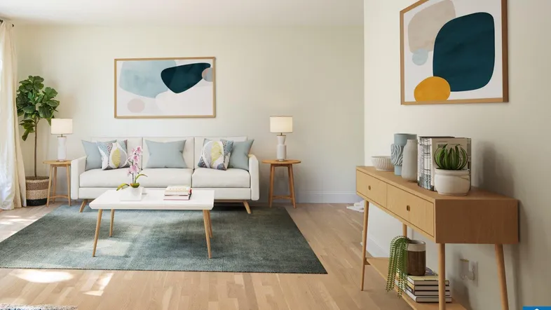 Helles, modernes Wohnzimmer mit hellem Holzboden, bequemer Couch und abstrakter Kunst an den Wänden.