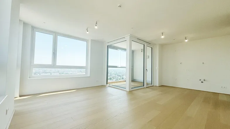 Helles Wohnzimmer mit Holzboden, großen Fenstern und weitem Stadtblick in einem Neubau.