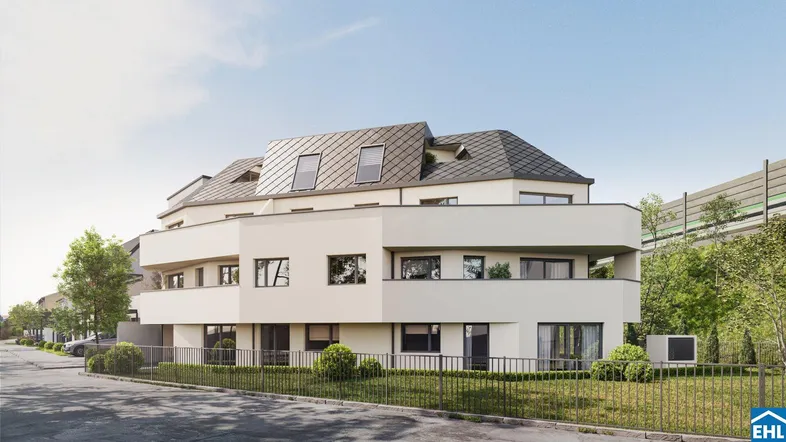 Moderne Wohnanlage mit heller Fassade, großen Fenstern und Dachschrägenfenstern.