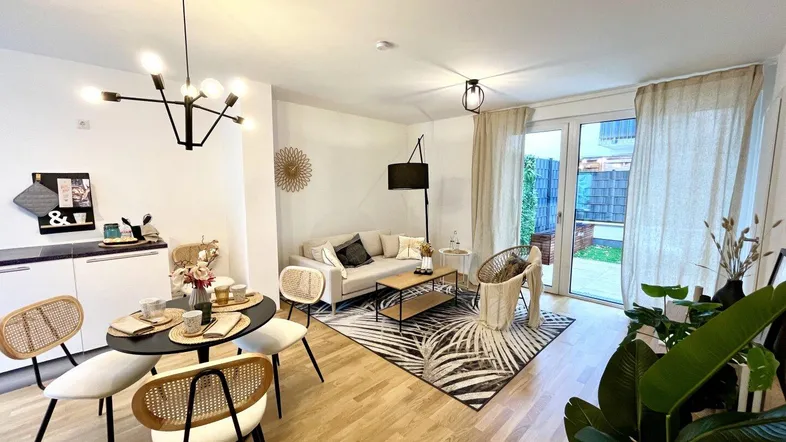 Heller, offener Wohn- und Essbereich mit modernem Design, Holzboden und Zugang zur Terrasse.