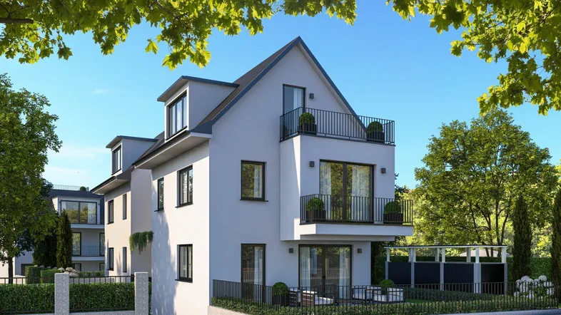 Moderne Wohnhausfassade mit Balkonen und kleiner Terrasse, umgeben von gepflegtem Grün.