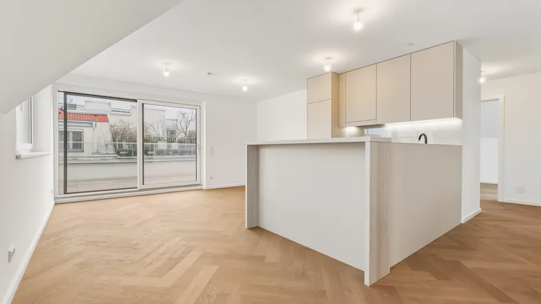 Offener Wohnbereich mit Kücheninsel, Fischgrätparkett und Zugang zur Terrasse.