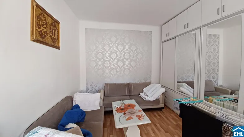 Gemütliches Wohnzimmer mit zwei Sofas, Holzboden und einem großen Spiegelschrank.